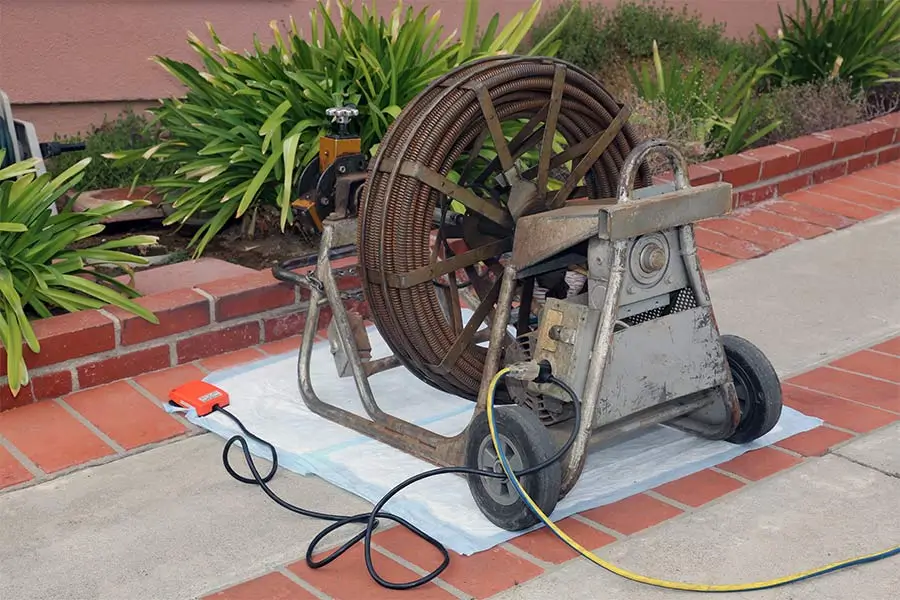 Heavy-duty drain cleaning machine with coiled cable